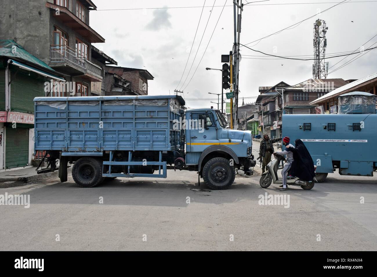 A paramilitary trooper seen stopping a  people on a scooter during restrictions in Srinagar, Kashmir. Authorities imposed restrictions in parts of the city in view of a strike called by the separatists against slapping of the Public Safety Act (PSA) on JKLF chairman Yasin Malik and ban on Jaamat-e-Islami (JeI). Stock Photo