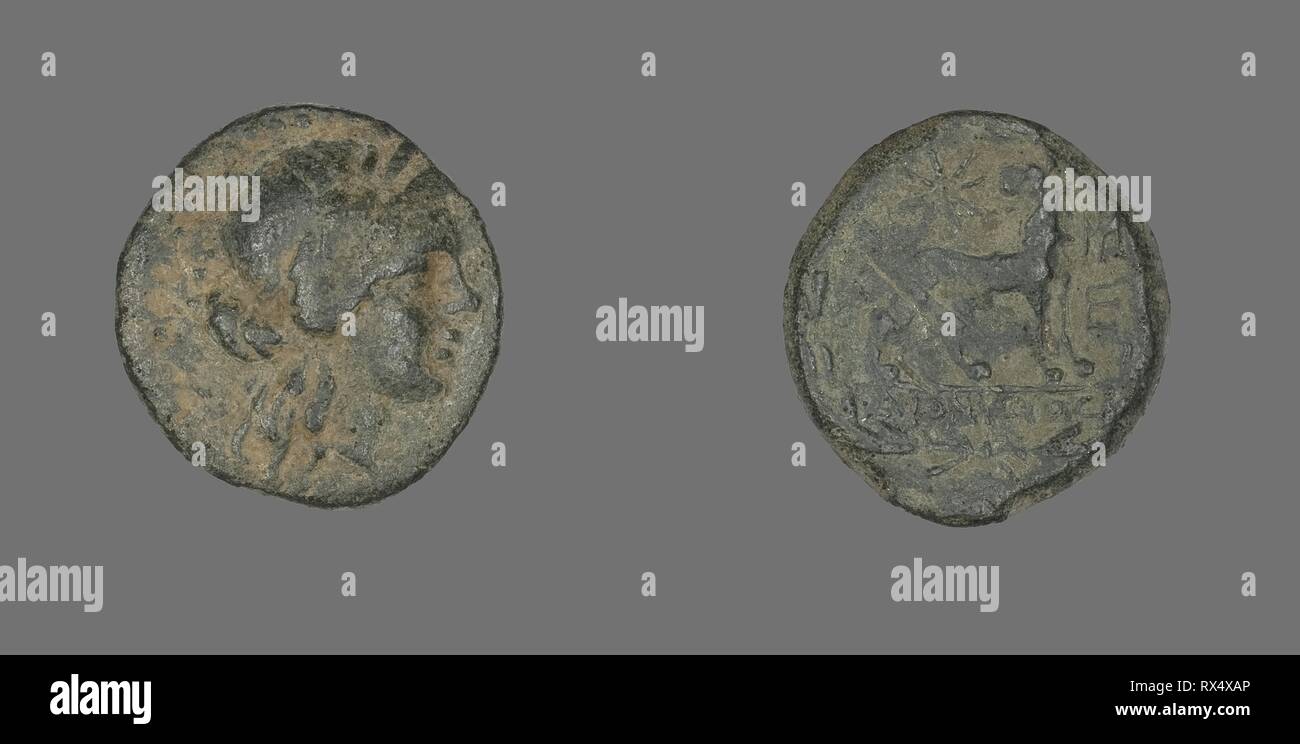 Coin Depicting the God Apollo. Greek. Date: 250 BC-190 BC. Dimensions: Diam. 2 cm; 4.70 g. Bronze. Origin: Ancient Greece. Museum: The Chicago Art Institute. Stock Photo