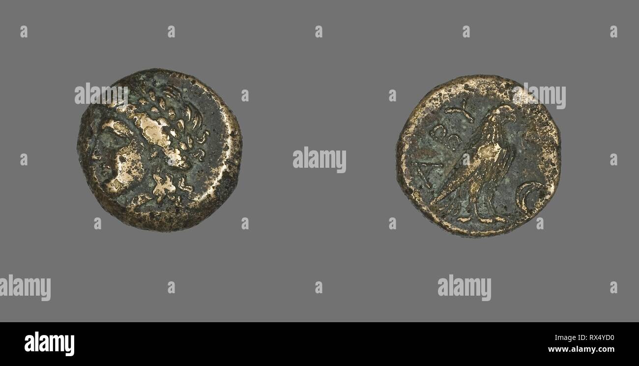 Coin Depicting the God Apollo. Greek. Date: 320 BC-200 BC. Dimensions: Diam. 1.7 cm; 4.20 g. Bronze. Origin: Ancient Greece. Museum: The Chicago Art Institute. Stock Photo