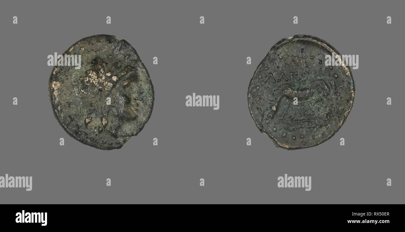 Coin Depicting the God Apollo. Greek. Date: 300 BC-100 BC. Dimensions: Diam. 1.8 cm; 2.85 g. Bronze. Origin: Ancient Greece. Museum: The Chicago Art Institute. Stock Photo