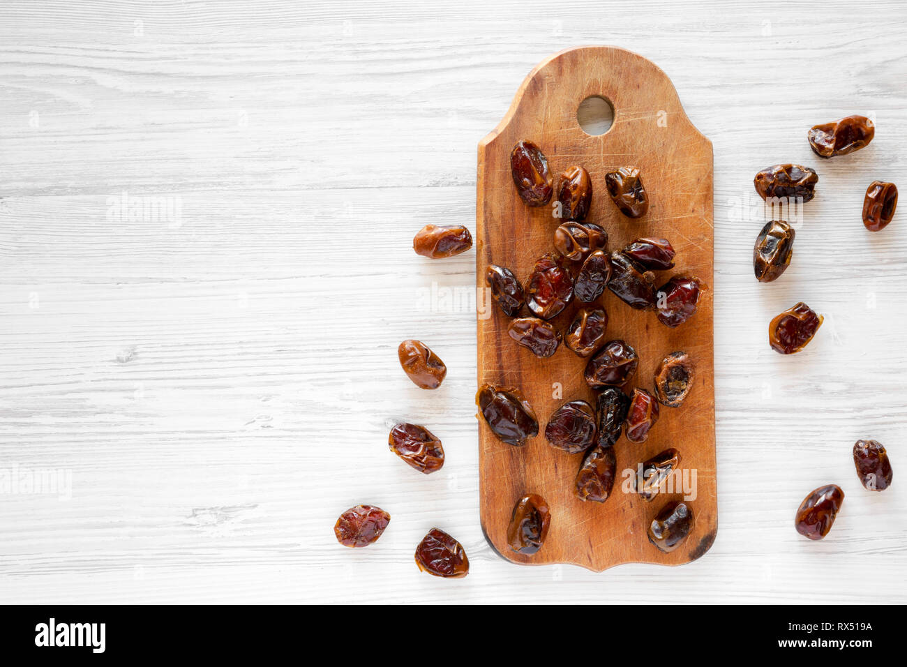 Dried dates on rustic wooden board on white wooden table, top view ...
