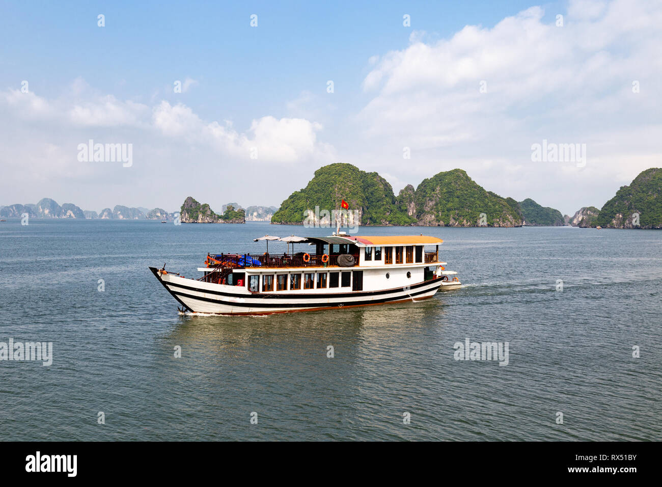 One of the many tour boats sailing among the karst formations in Halong Bay, Vietnam, in the gulf of Tonkin. Halong Bay is a UNESCO World Heritage Sit Stock Photo