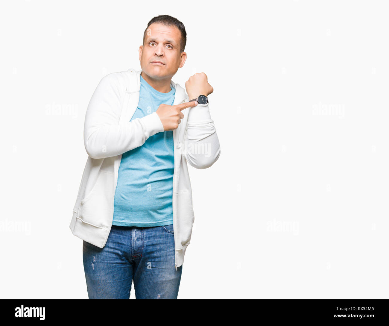 Middle age arab man wearing sweatshirt over isolated background In hurry pointing to watch time, impatience, upset and angry for deadline delay Stock Photo