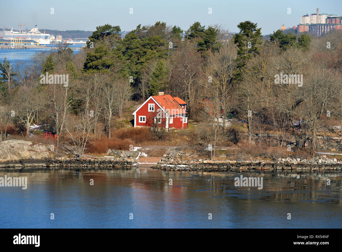 Red wooden house on background of Stockholm port Stock Photo