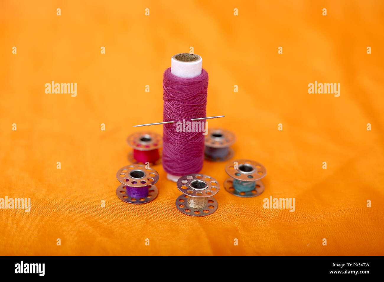 Picture of many bobbin, thread and needle . Isolated on the yellow ...