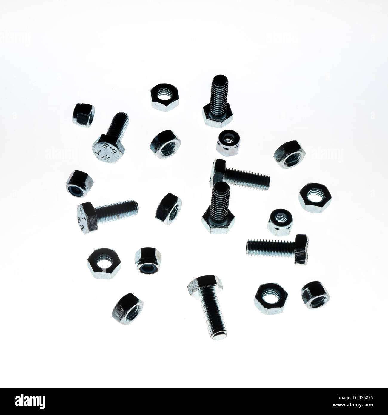 some lock nuts and bolts of various sizes on a white background Stock