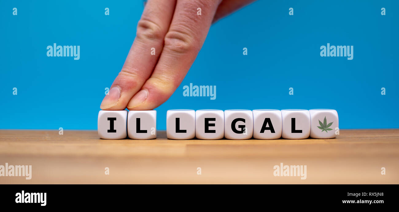 Symbol for Marijuana Legalization. Dice form the word "ILLEGAL" while two fingers push the letters "IL" away in order to change the word to "LEGAL". Stock Photo