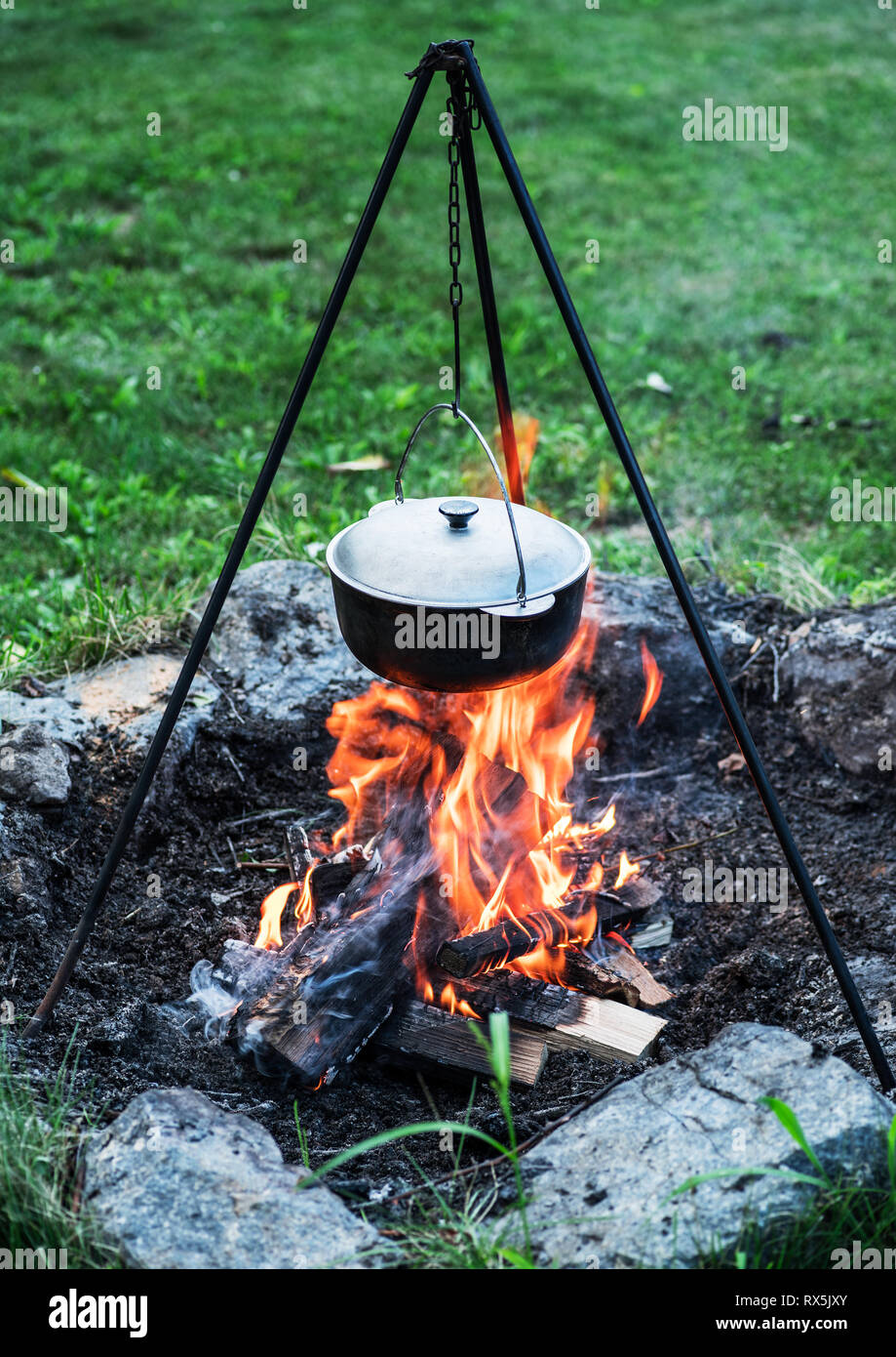 Cauldron over the fire. Preparing food on the campfire. Stock Photo