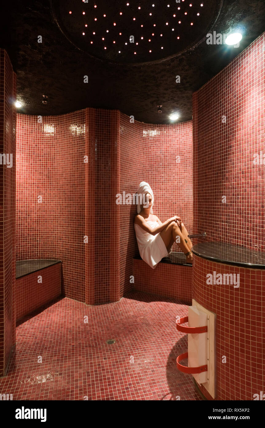 Woman in red tiled sauna Stock Photo