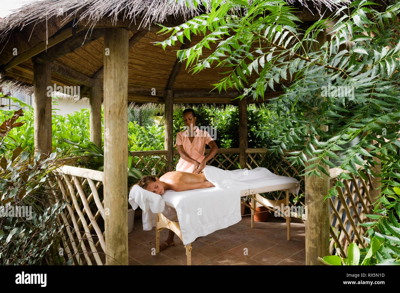 Woman receiving massage in thatched gazebo Stock Photo