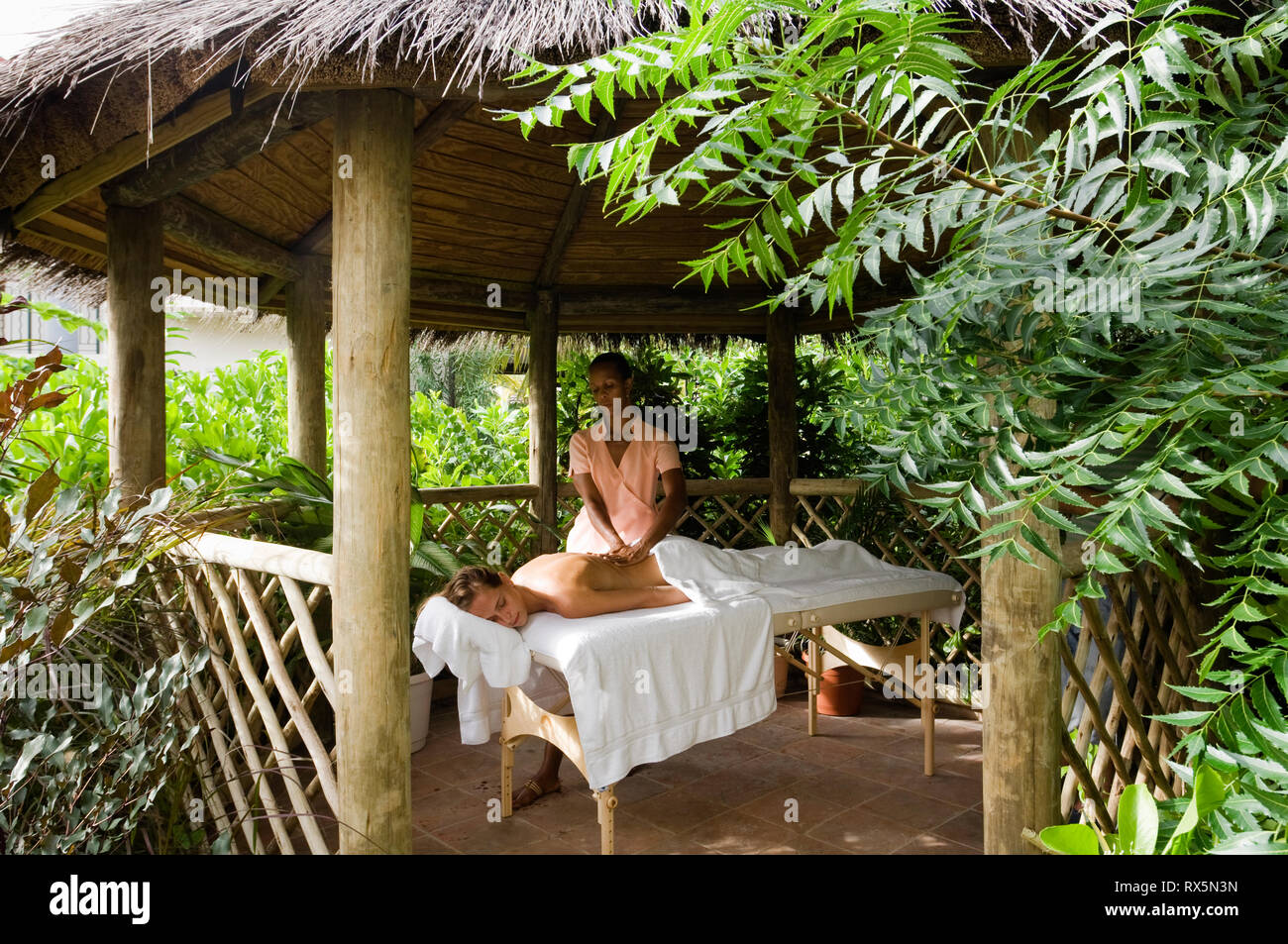 Woman receiving massage in thatched gazebo Stock Photo