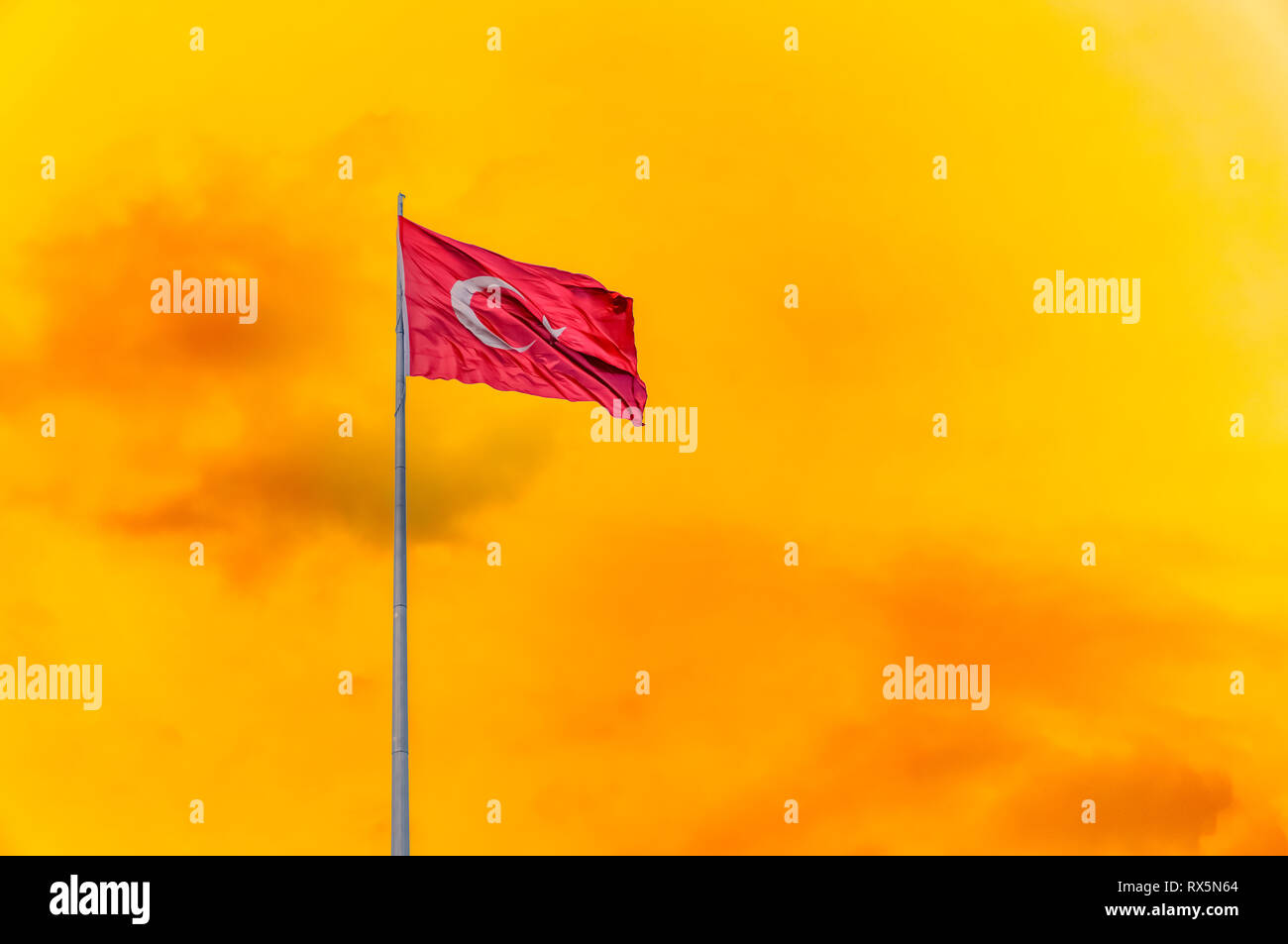 Turkish flag waving in orange color sky. Stock Photo