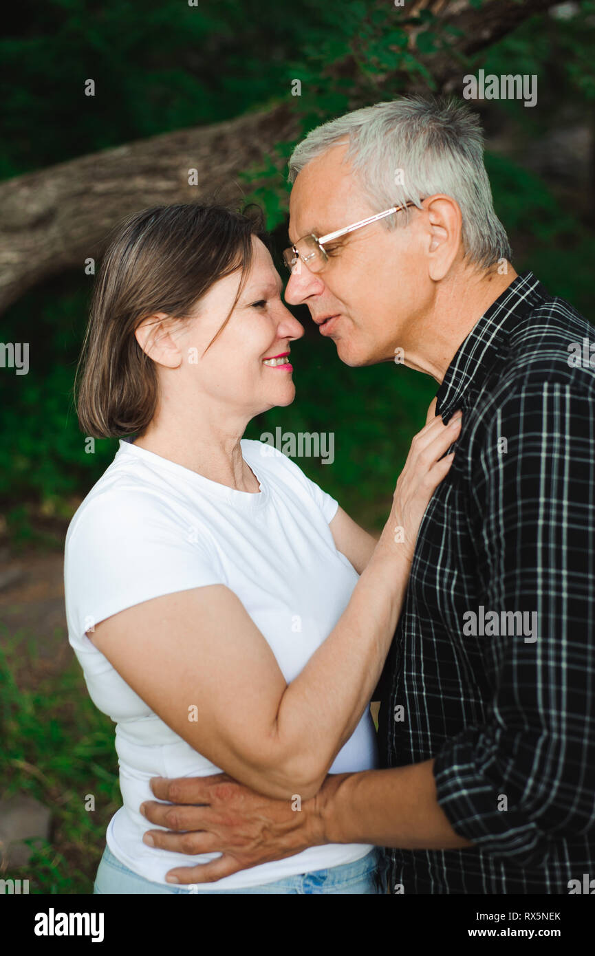 Romantic walk through the woods. Senior couple walking together in a ...