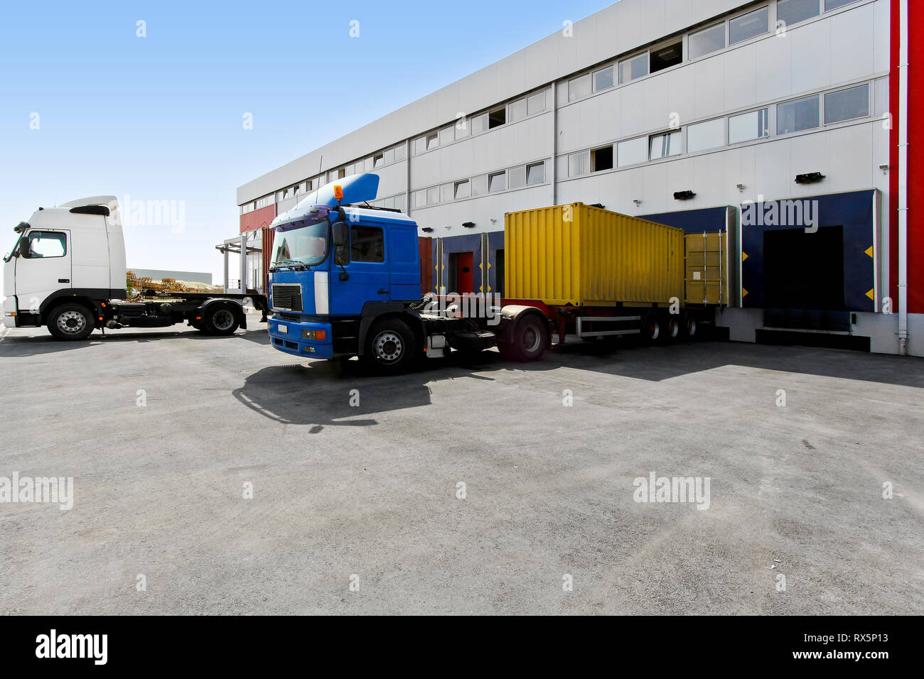 Unloading big container trucks at warehouse building Stock Photo