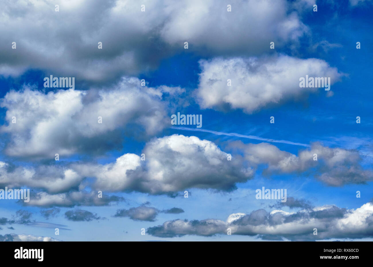 Pictured are clouds against a blue sky. Stock Photo