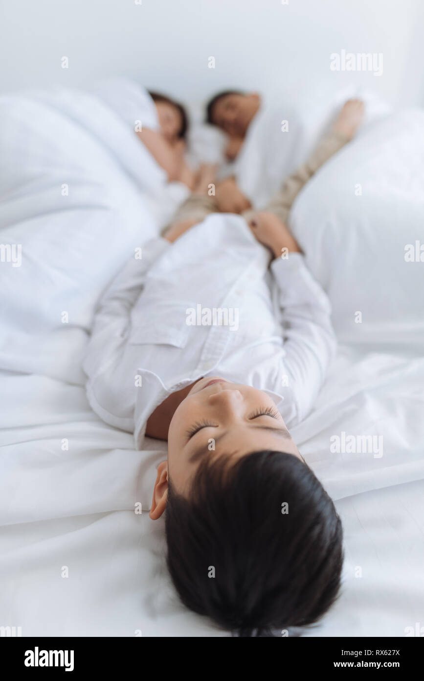 boy sleeping toss and turn in my sleep with his family in bed Stock