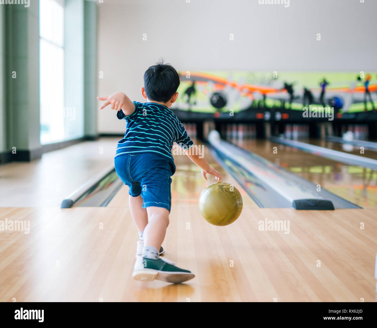back view child throwing bowling ball Stock Photo Alamy