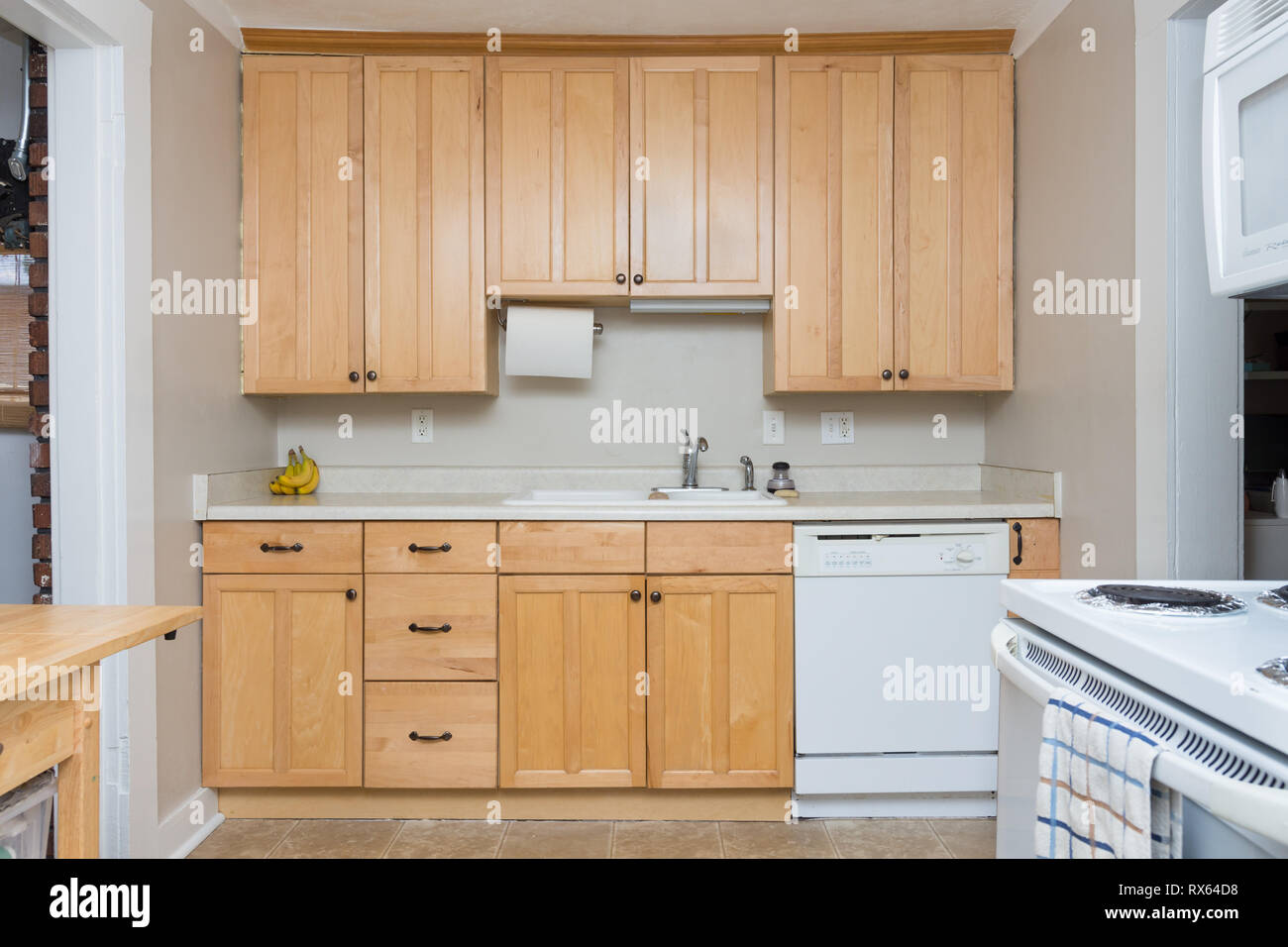 Clean Light Tan Wood Cabinets In Small Kitchen Space Stock Photo