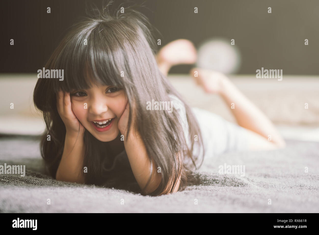 happy little girl laying on the bed Stock Photo