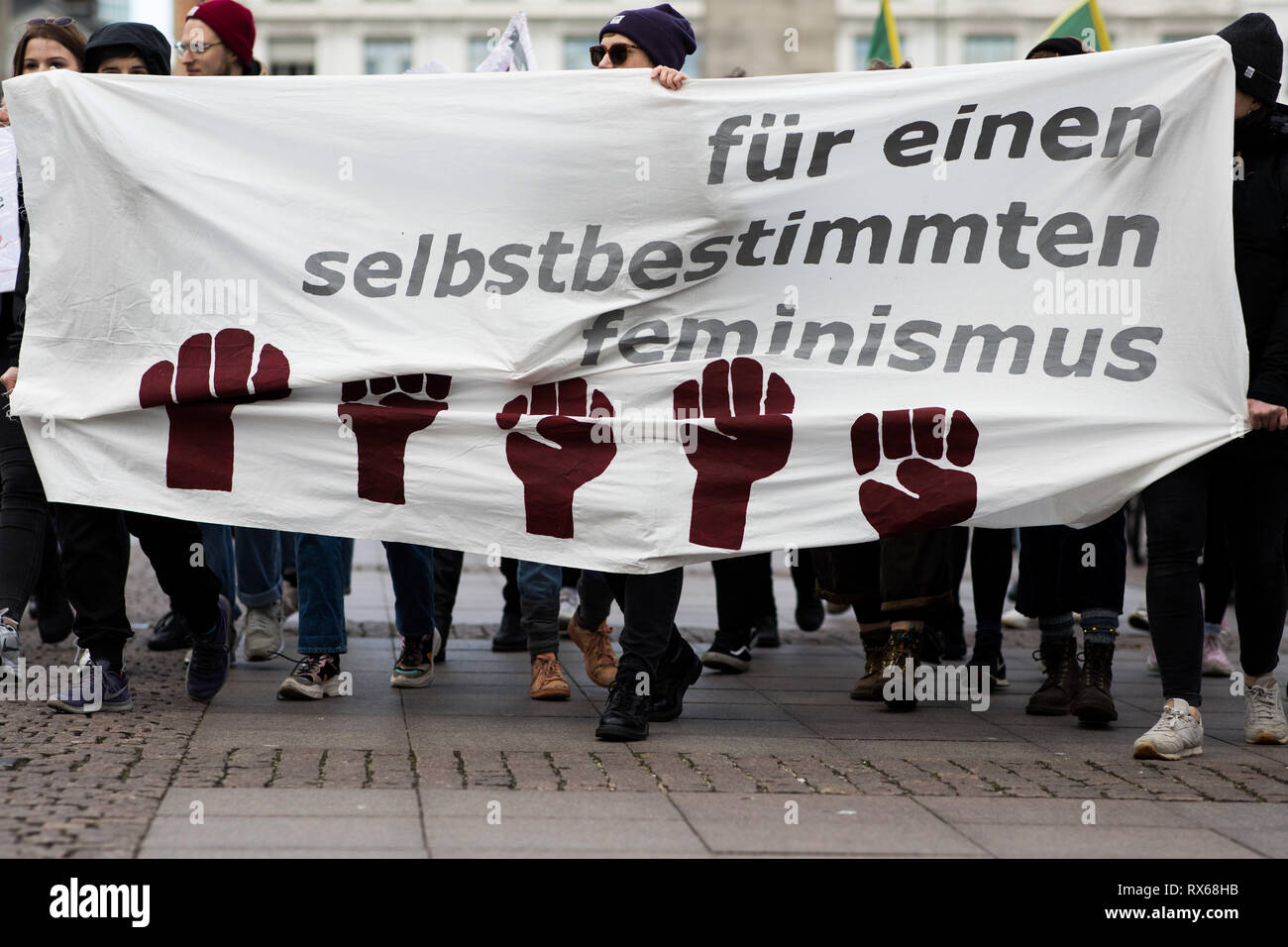 Hamburg, Germany. 08th Mar, 2019. Participants stand with a banner at a demonstration on International Women's Day on the town hall market. Parties, unions, and women's rights organizations have called for a rally for more equality in front of the Hamburg City Hall on World Women's Day. At the same time, the 'Hamburg Alliance for the International March 8 Strike' called on all 'women, lesbians, non-binary, trans and inter persons' to lay down their work. Credit: Christian Charisius/dpa/Alamy Live News Stock Photo