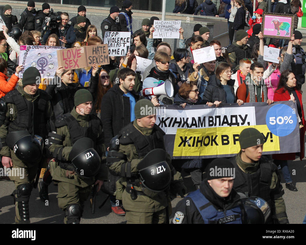 Ukrainian police officers and National guards are seen accompanying protesters holding banners, placards and flags during the demonstration. Ukrainian feminists and their supporters held their march demanding for rights of women worldwide and against domestic violence during The International Women's Day which is celebrated annually on March 8. Stock Photo