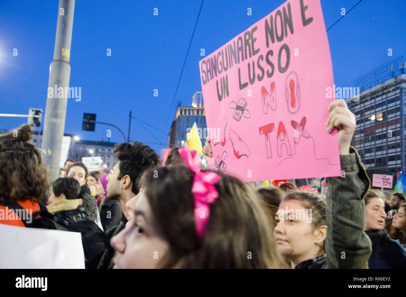 Milan, Italy. 8th Mar 2019. Women hold a sign that reads bleeding is not luxury at International Women's Day In Milano Stock Photo