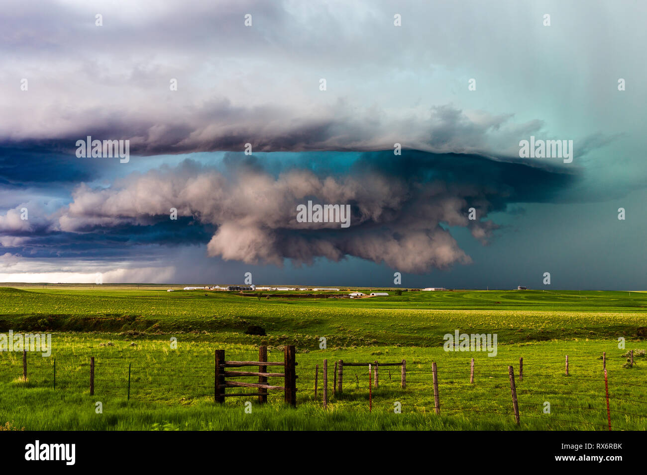 Supercell thunderstorm with dramatic clouds spins across the rolling grasslands near Ryegate