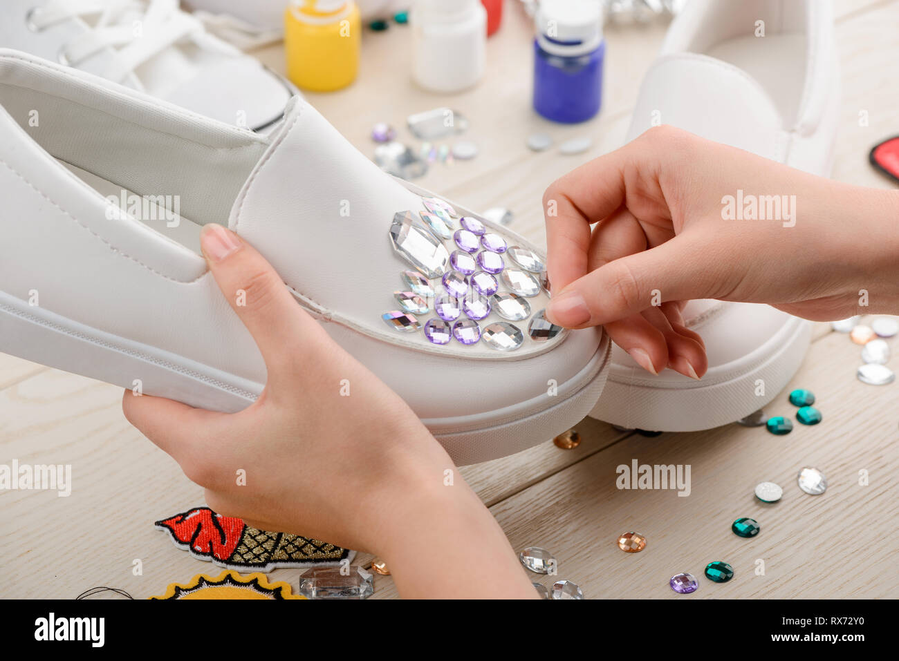 Girl putting rhinestones onto shoes Stock Photo Alamy