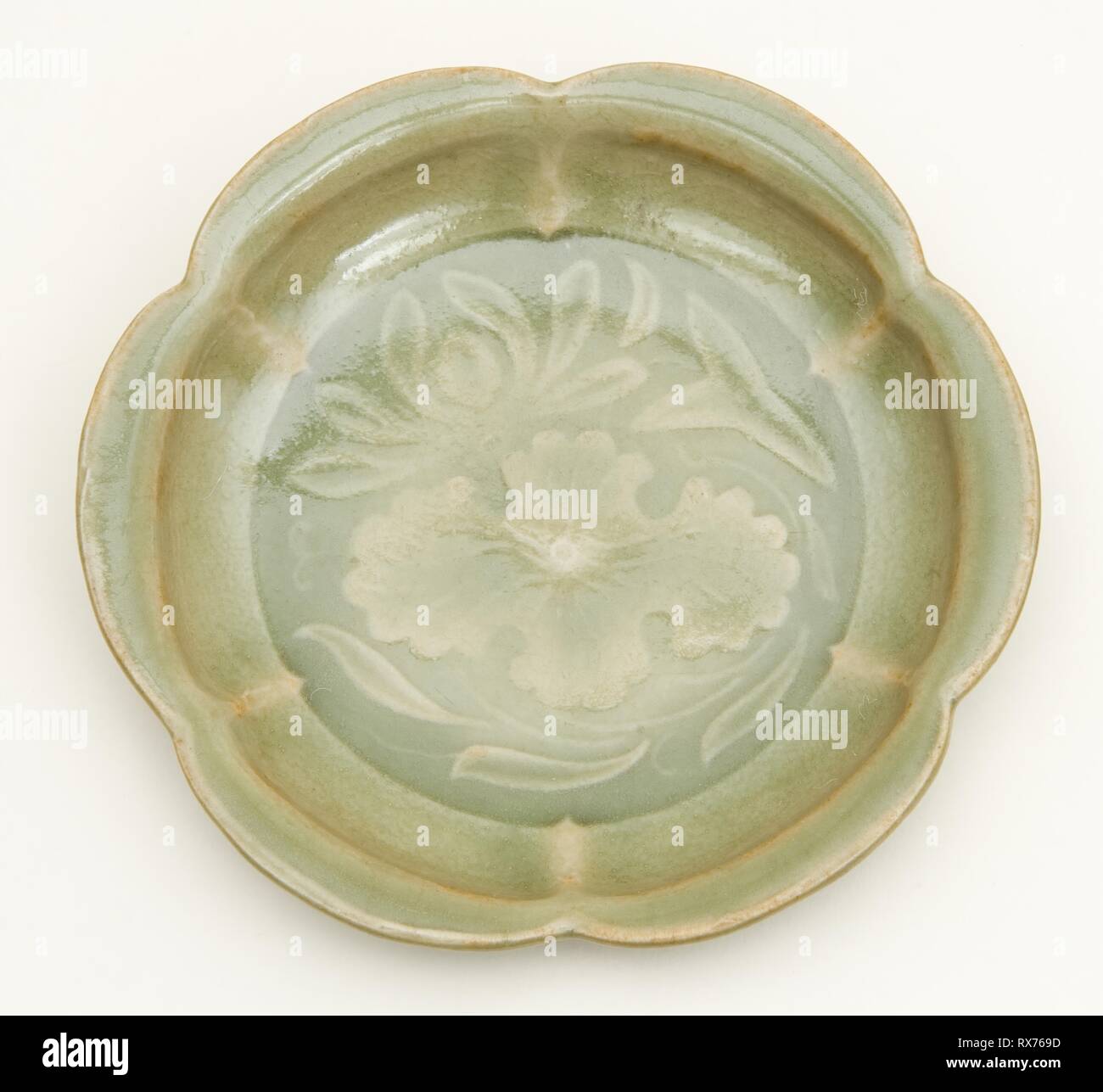 Dish with Petal-Lobed Rim, Lotus, and Waterweeds. China. Date: 1000-1127. Dimensions: H. 2.8 cm (1 1/8 in.); diam. 10.9 cm (4 5/16 in.). Yaozhou ware; stoneware with underglaze molded decoration. Origin: China. Museum: The Chicago Art Institute. Stock Photo