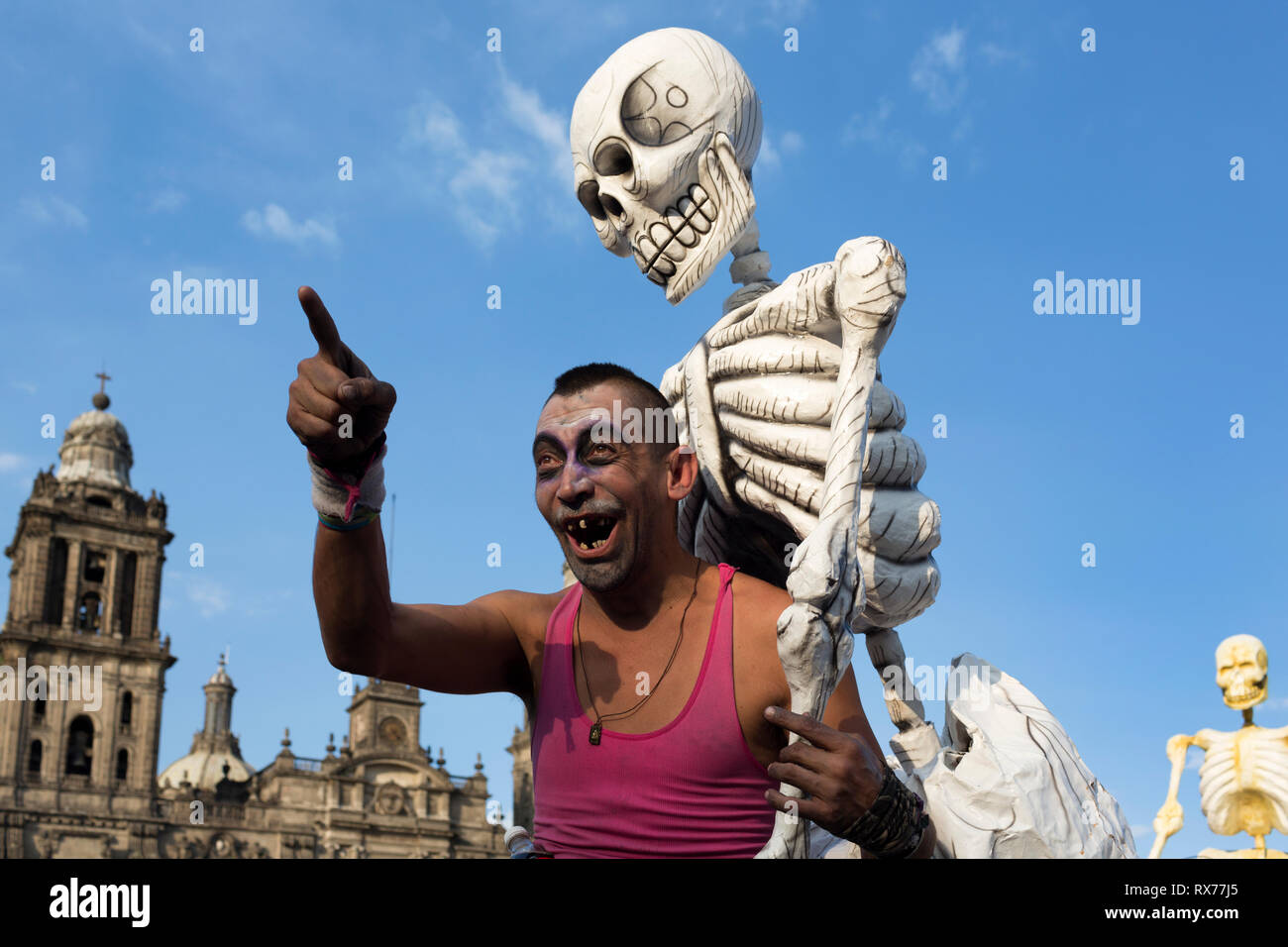 A man jokes with one of the skeletons that were part of a sculptural installation tribute to Jose Guadalupe Posadas, the creator of Catrina. Stock Photo