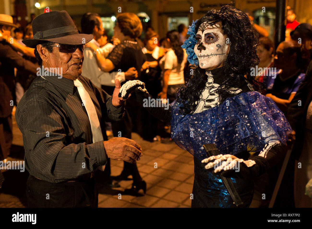 Some of the attendees come disguised as the dead to the dance held in the city square on the occasion of the celebration of the Day of the Dead. Stock Photo