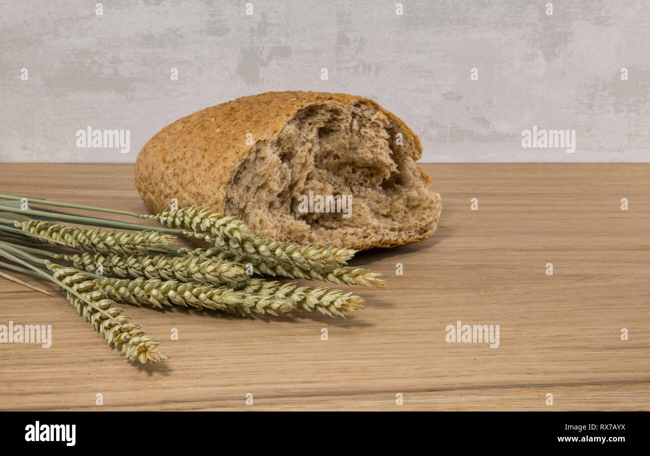 A wheat bread and shock of wheat on a wooden background Stock Photo