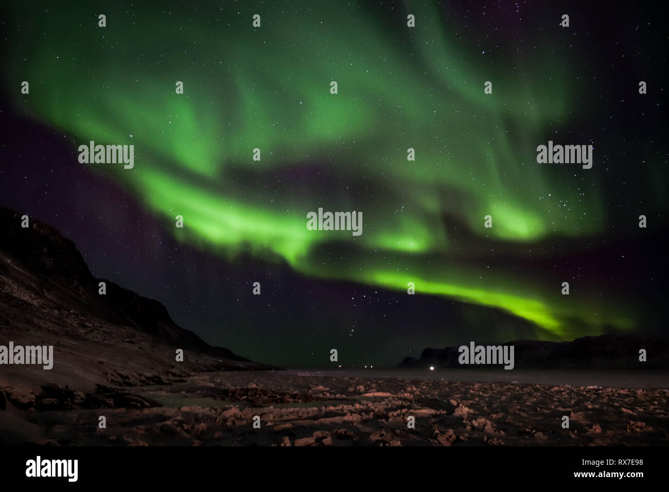 Aurora Borealis viewed from the small Arctic town of Pangnirtung over the frozen Cumberland Sound. Stock Photo