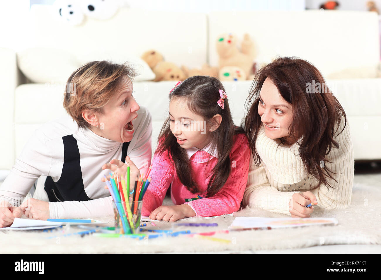 little girl draws with her mother and grandmother Stock Photo Alamy