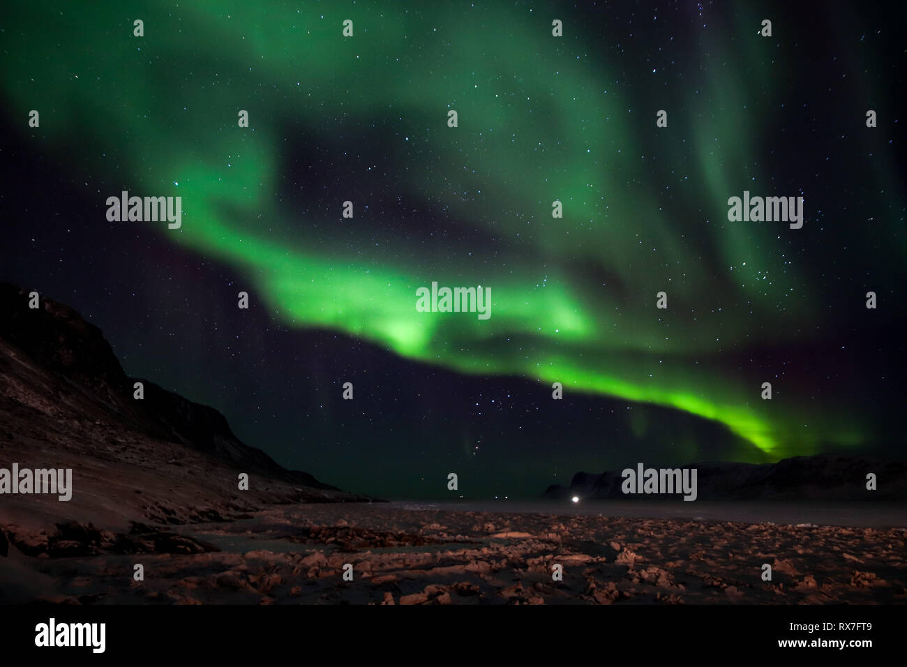 Aurora Borealis viewed from the small Arctic town of Pangnirtung over the frozen Cumberland Sound. Stock Photo