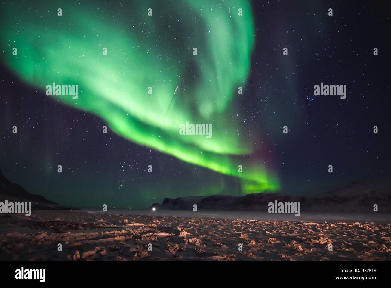 Aurora Borealis viewed from the small Arctic town of Pangnirtung over the frozen Cumberland Sound. Stock Photo