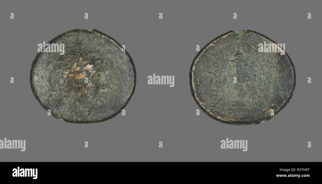 Coin Depicting the God Apollo. Greek. Date: 238 BC-183 BC. Dimensions: Diam. 2.1 cm; 5.26 g. Bronze. Origin: Ancient Greece. Museum: The Chicago Art Institute. Stock Photo