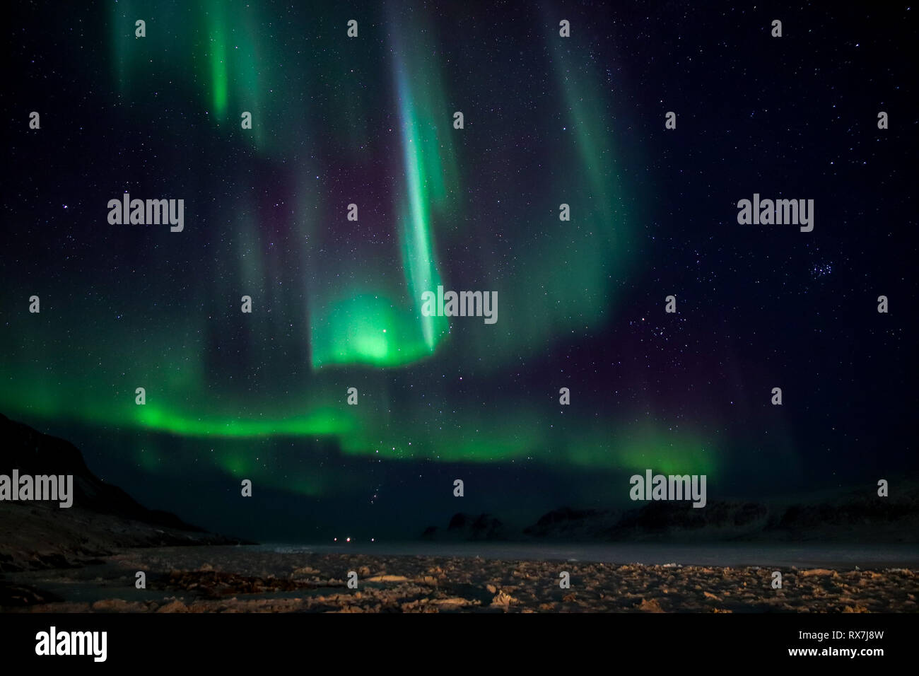 Aurora Borealis viewed from the small Arctic town of Pangnirtung over the frozen Cumberland Sound. Stock Photo