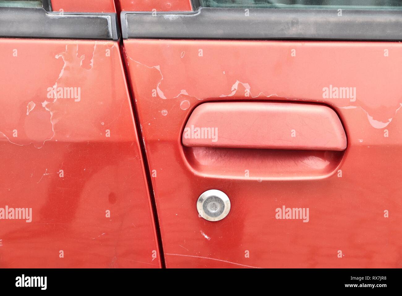 Fading car paint peeling paint surface in a 20 year old European red