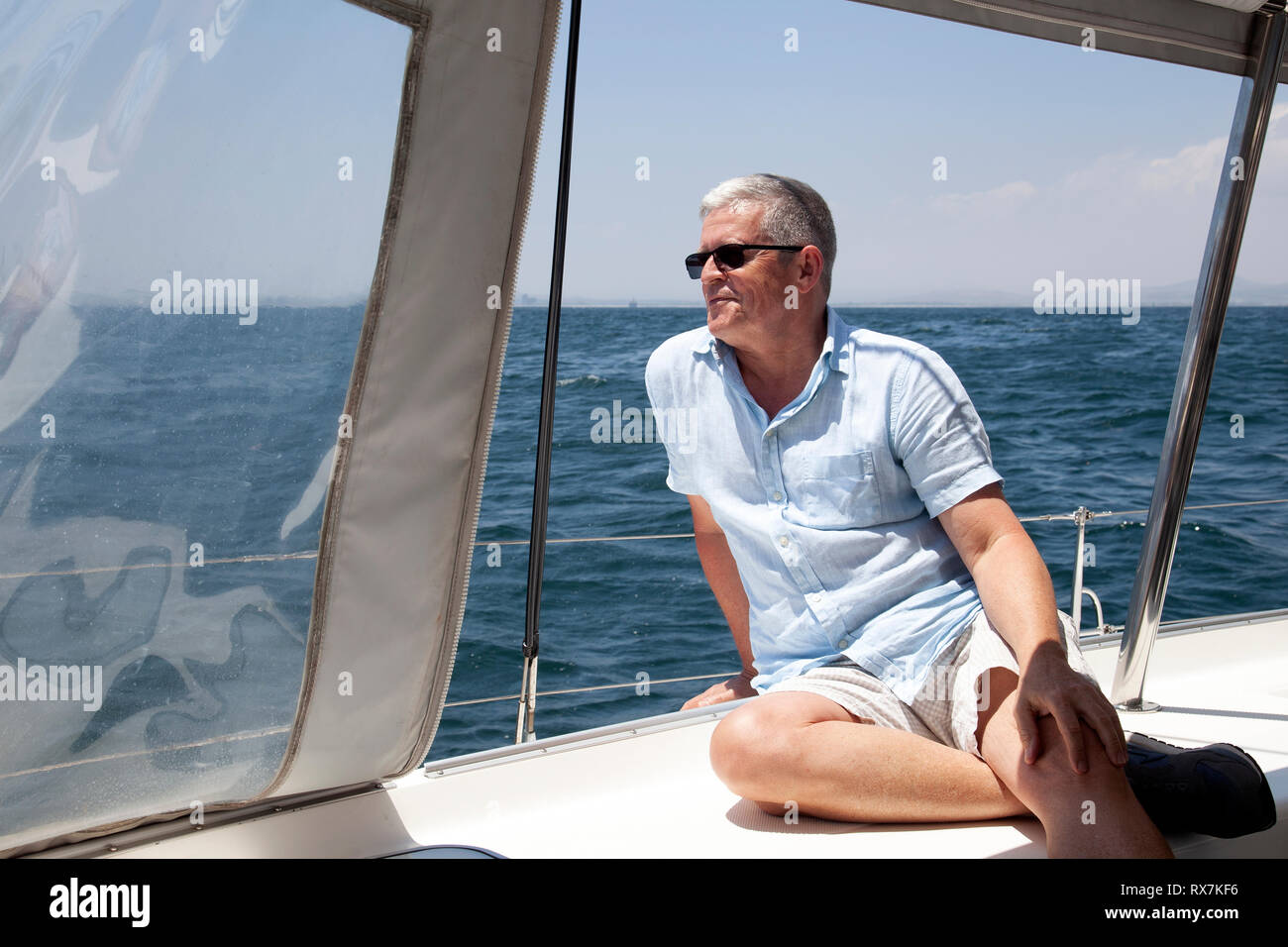 Man on Catamaran at Sea in Table Bay, Cape Town, South Africa Stock Photo