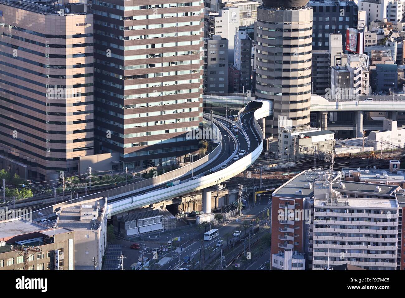 OSAKA, JAPAN - APRIL 27: Cars ride through Gate Tower Building on April 27, 2012 in Osaka, Japan. The building is extremely popular because of highway Stock Photo