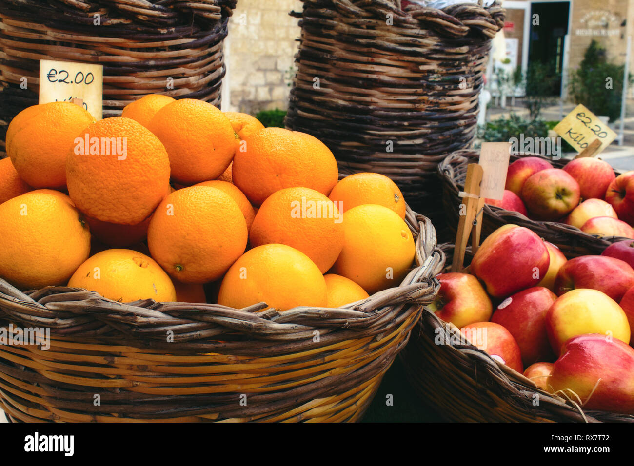 Market vendor cart with varied fruit in wicker baskets Stock Photo