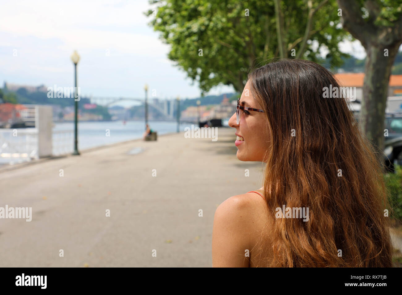 Happy smiling girl in Porto City, Portugal. Beautiful young tourist woman traveling in Europe. Stock Photo