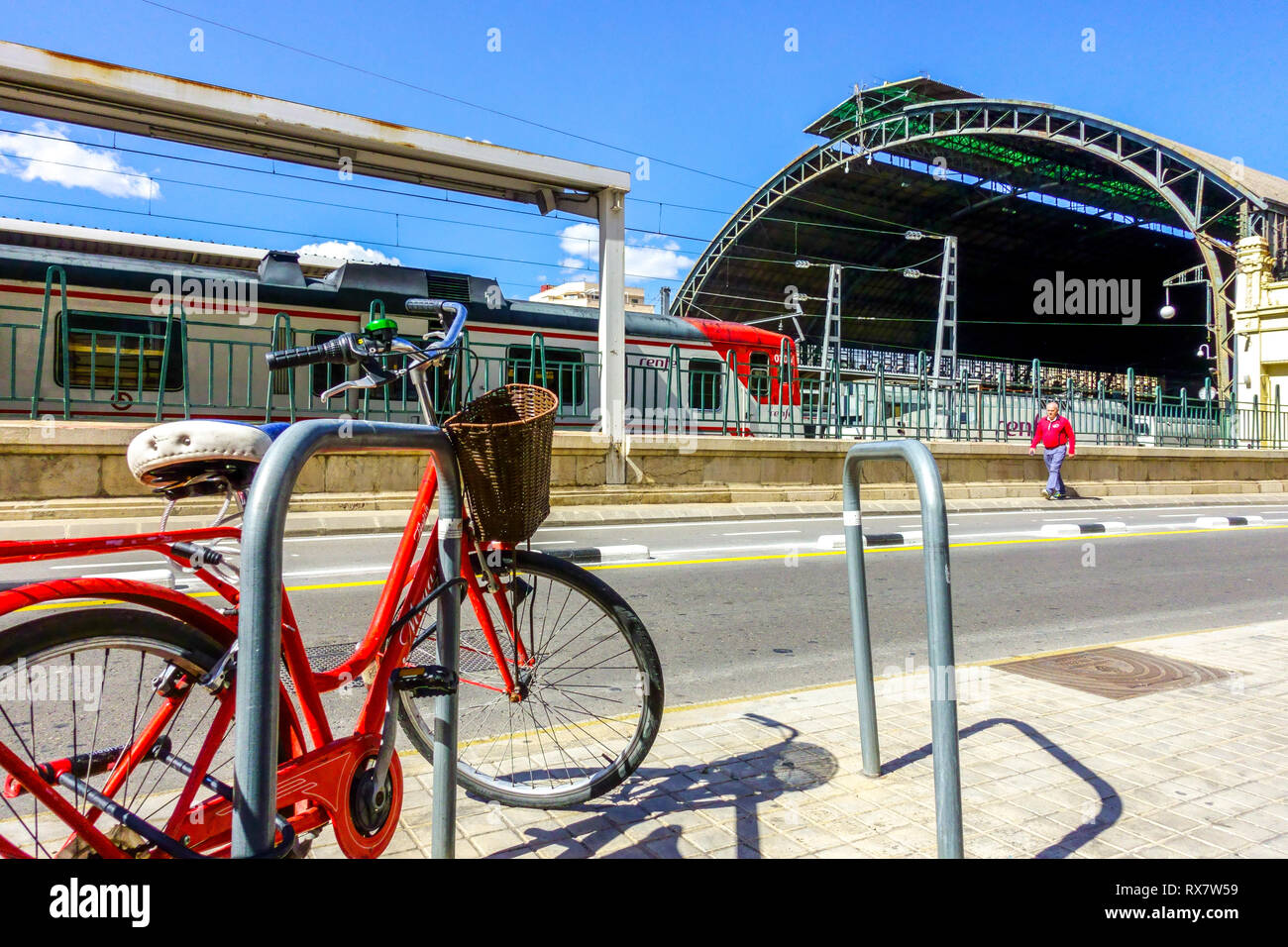 Red bike parked in front of main railway station Valencia Spain Stock Photo
