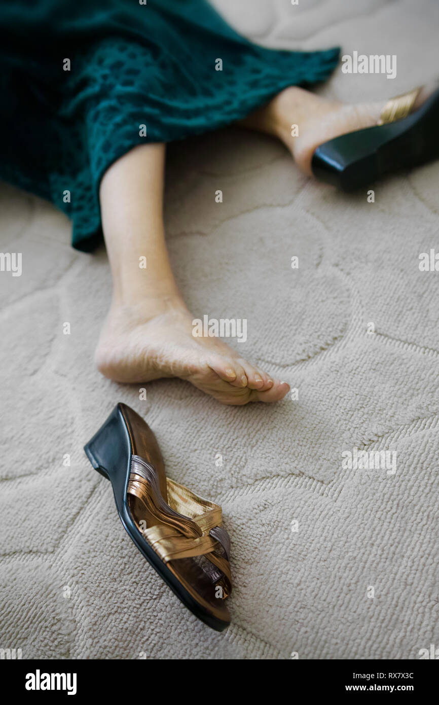 On the carpet we see a sandal lost from the foot of this elderly lady