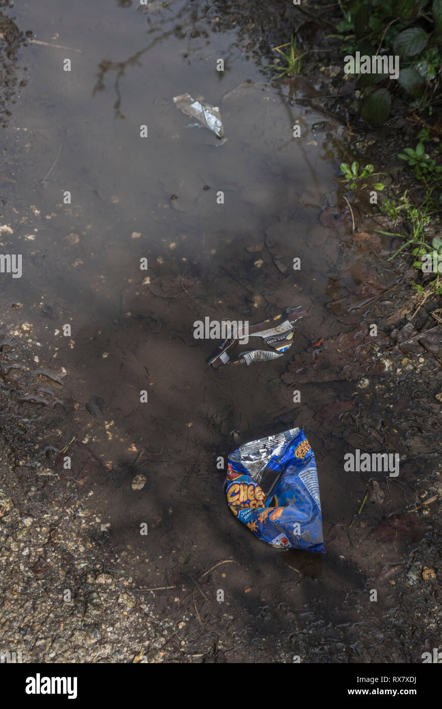 Discarded plastic food packaging on a rural countryside footpath in UK