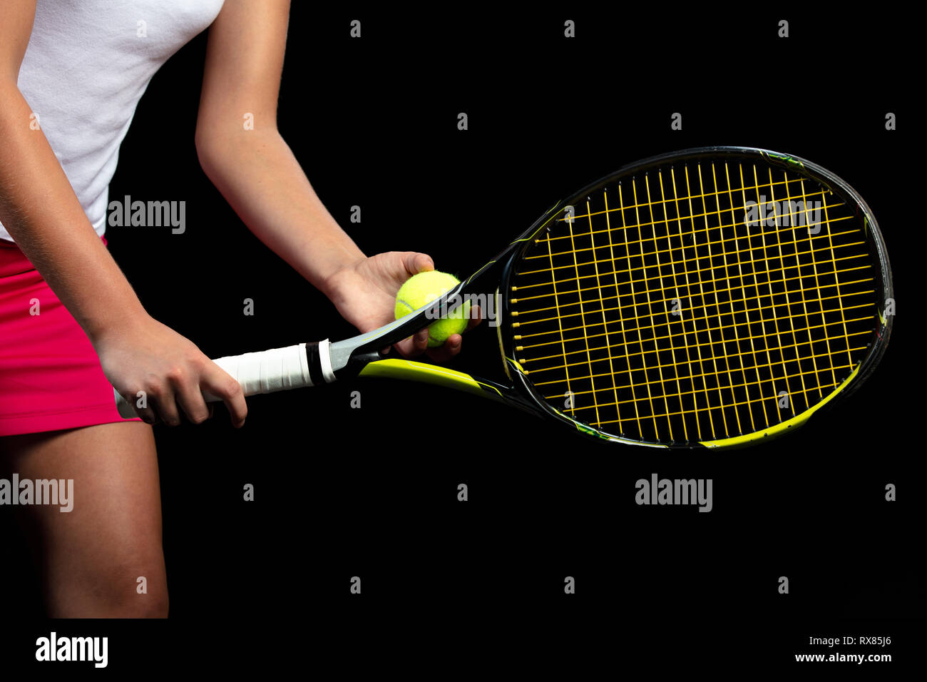 Young woman on a tennis practice. Beginner player holding a racket,  learning basic skills. Portrait on black background Stock Photo - Alamy