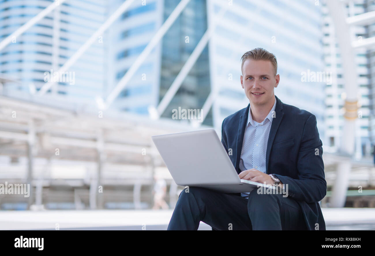 businessman using laptop in urban city Stock Photo