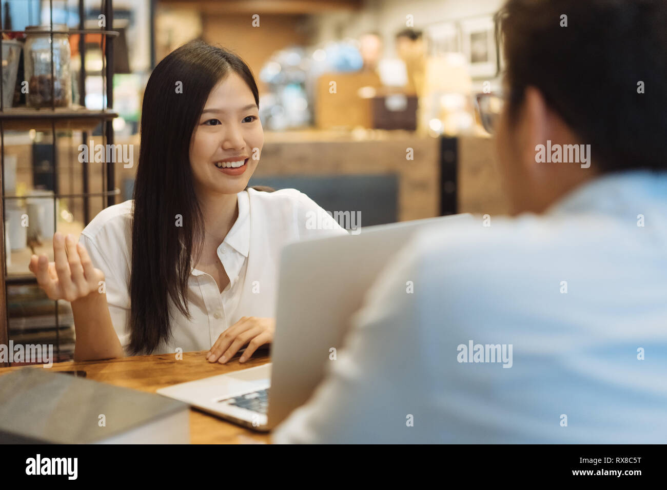 Young Asian woman sitting in cafe talking and having a meeting. Stock Photo