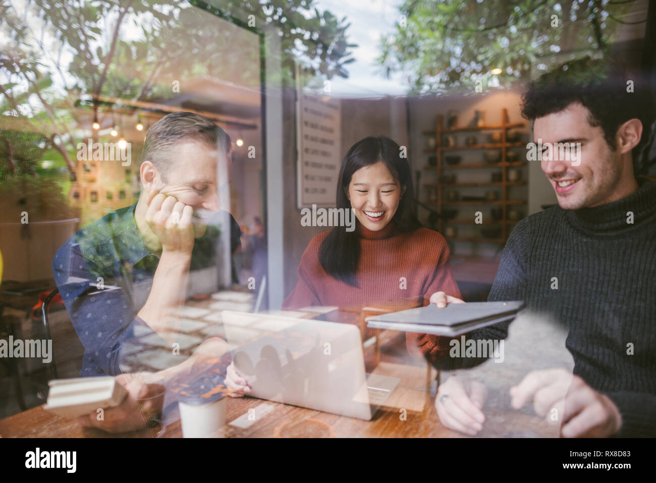 Group of friends chatting and using laptop in cafe at the coffee shop ...